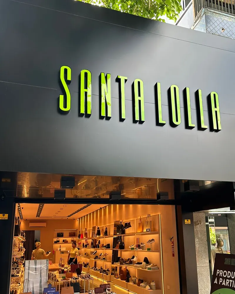 Fachada da Santa Lolla na Avenida Brasil ao entardecer, com o letreiro em verde neon aceso